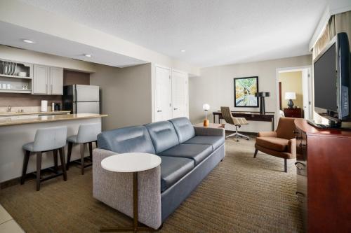 a living room with a couch and a kitchen at Residence Inn by Marriott Seattle/Bellevue in Bellevue