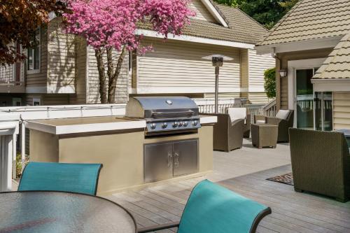 a grill on a patio with tables and chairs at Residence Inn by Marriott Seattle/Bellevue in Bellevue