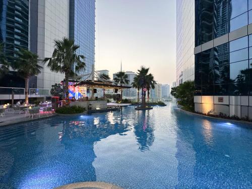 a large swimming pool in a city with tall buildings at Luxurious 2BDR Apartment in Paramount Towers with Burj Khalifa Views in Dubai