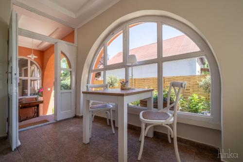 a dining room with an arched window and a table and chairs at Délceg Réce Minihotel in Balatonkenese