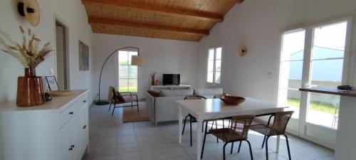 une cuisine et un salon avec une table et des chaises dans l'établissement A 500m de l'océan pour 4 personnes, à Saint-Denis-dʼOléron