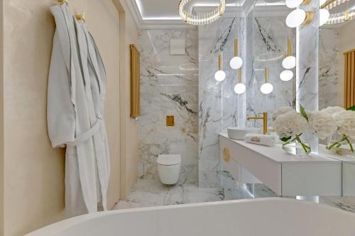 a white bathroom with a tub and a sink at Jacuzzi Mirror Suite by Downtown Apartments in Gdańsk