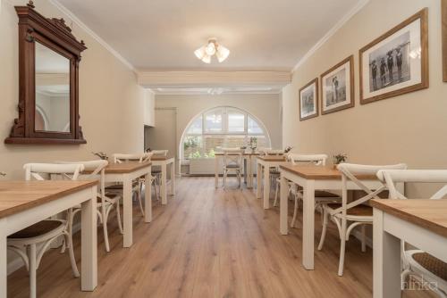 a restaurant with tables and chairs and a window at Délceg Réce Minihotel in Balatonkenese