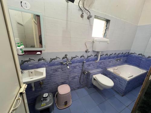 a blue and white bathroom with a sink and a toilet at Mikunj Farms Karjat in Karjat