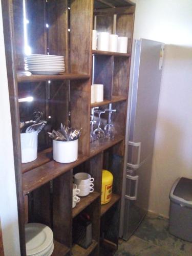 a bathroom with a wooden shelf with dishes and a toilet at Kampala Farm in Bonnievale