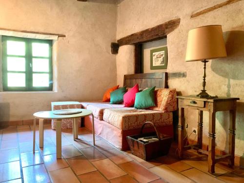 - un salon avec un canapé et des oreillers colorés dans l'établissement Jourcins Jardin avec vue Montagne, à Saint-André-dʼEmbrun