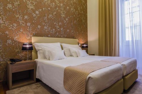 a bedroom with a large bed with white pillows at Hotel INN Rossio in Lisbon