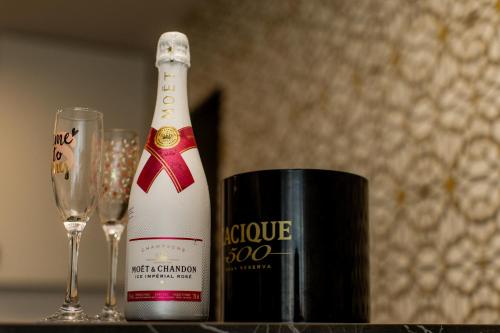 a bottle of champagne next to two glasses on a table at Desire Loft in Alba Iulia