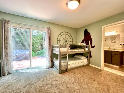 a bedroom with two bunk beds and a sliding glass door at Forest cottage - secluded, hot tub, walk to beach in Rockaway Beach