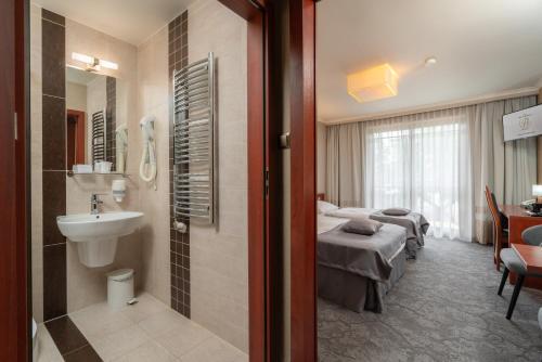 a hotel room with two beds and a sink at Hotel Badura in Wadowice