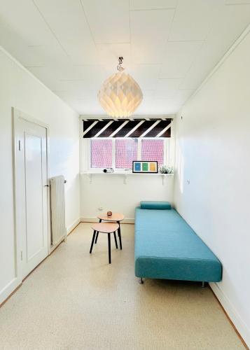 a room with a blue bed and a table at CozyHouse in Halmstad