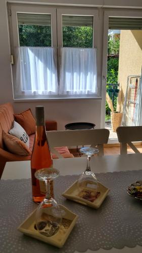 a bottle of wine and two glasses on a table at Apartman LiBra in Banja Koviljača