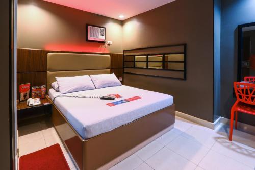 a bedroom with a bed and a red chair at Hotel Sogo Santa Mesa in Manila