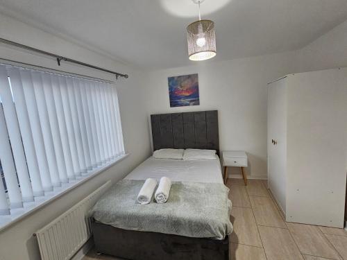 a bedroom with a bed with two white shoes on it at 66 Central Road in Kent