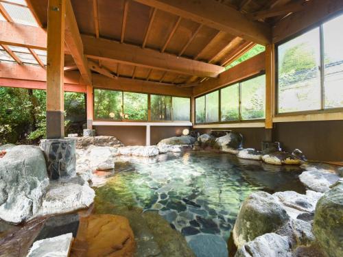 a pool of water with rocks in a house at Iwazonokan in Minami Alps