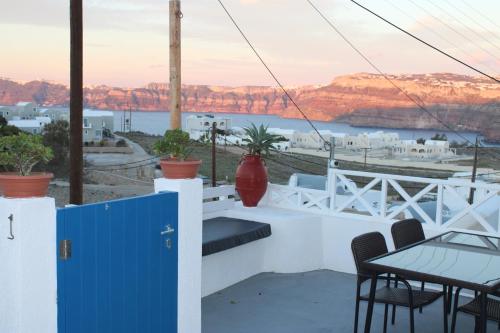 a balcony with a table and chairs and a view of the water at Mary Castelia Villa with Jacuzzi in Akrotiri