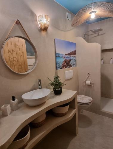 a bathroom with a sink and a mirror on the wall at Les Spas de la Mer, Appart&Spa Aloha, 100m de la plage, Plein cœur du Grau in Le Grau-du-Roi