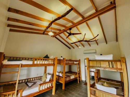 a room with four bunk beds in it at PIDA COFFEE FARM LODGE in Phumĭ Pu Pal