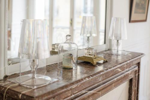 une table avec deux vases en verre et un miroir dans l'établissement Appartement d'une chambre près de Montmartre, à Paris