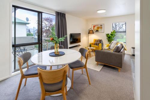 a living room with a table and chairs at Warm CHCH Apartment Park View & Garage Parking in Christchurch
