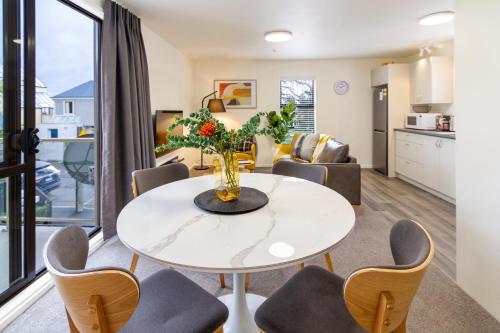 a living room with a white table and chairs at Warm CHCH Apartment Park View & Garage Parking in Christchurch