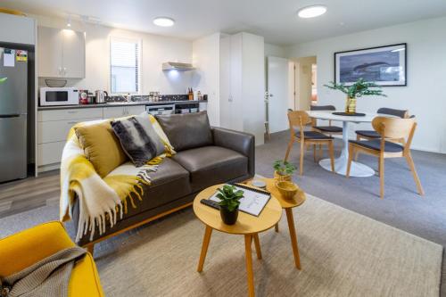a living room with a couch and a table at Warm CHCH Apartment Park View & Garage Parking in Christchurch