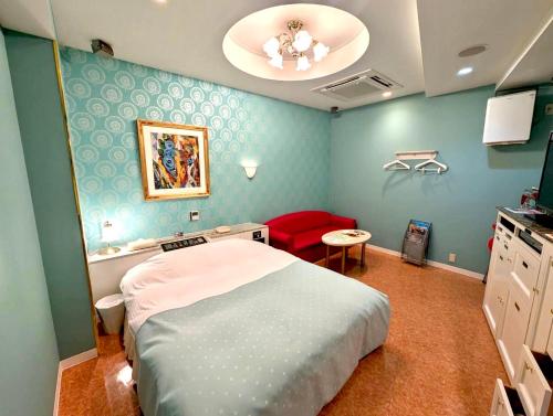 a bedroom with a large bed and a red chair at HOTEL ベアーズadults only in Tenri