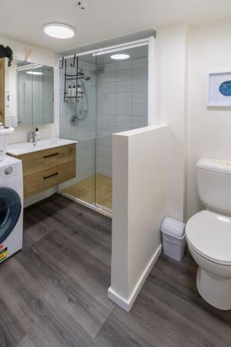 a bathroom with a shower and a toilet and a sink at Warm CHCH Apartment Park View & Garage Parking in Christchurch