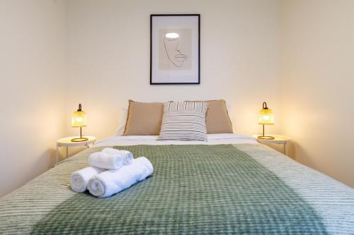 a bedroom with a bed with towels on it at Warm CHCH Apartment Park View & Garage Parking in Christchurch