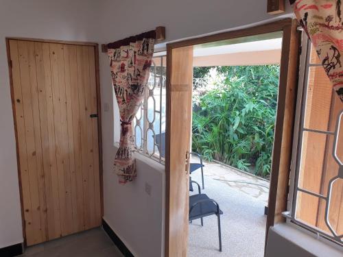 an open door to a balcony with a chair at Alison & Dave's Guesthouse in Entebbe