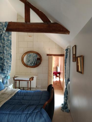 - une chambre avec un lit bleu et une table dans l'établissement LE COMPOSTELLE BATIMENT LA RENAISSANCE, à Courchamps