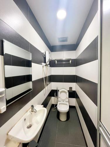 a bathroom with a toilet and a sink at Rich Hotel in Kampong Ayer Hitam Batu Satu