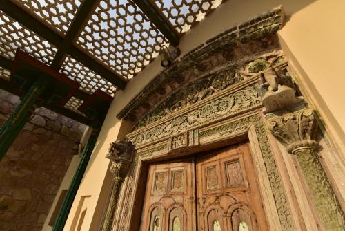 a wooden door with a statue on top of it at Haveli Anirudh - Royalty Redefined in Jaipur
