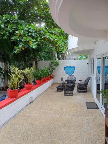 a patio with chairs and potted plants on a wall at Arizona Beach Resort, Subic Bay, Philippines 2200 in Olongapo