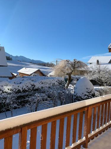 une cour enneigée avec une balustrade en bois dans l'établissement Chambre sur St hilaire du touvet, à Saint-Hilaire