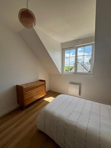 une chambre blanche avec un lit et une fenêtre dans l'établissement Ty Mamie spa - 700m de la plage, à Saint-Pabu
