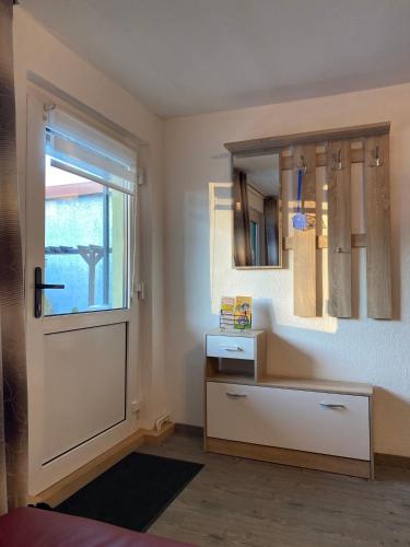 a room with a door and a drawer and a mirror at Bungalow am Hellbach XL im Ostseeland in Neubukow