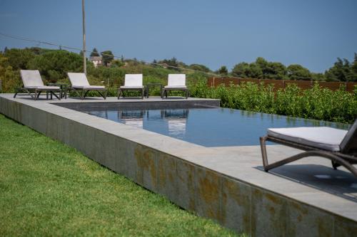 a swimming pool with lounge chairs sitting around it at MòN Luxury Rooms SPA in Nicolosi