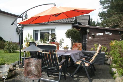 a table with an umbrella in front of a house at Ferienhaus am Waldrand Biendorf bei Kühlungsborn in Biendorf