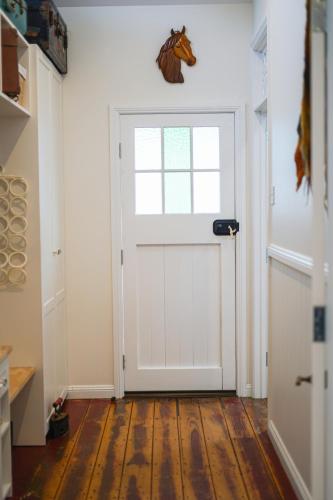 a white door with a horse head on the wall at Entire Boutique Home - The Rustic Cottage - Canungra in Canungra