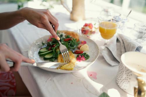 een persoon die een bord eten met een vork en mes bij Peetri talu klaaskuplid Haapsalu lähedal in Rootsi