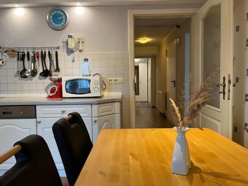 una cucina con tavolo in legno e forno a microonde di FeWo Alt Bukow nahe Ostseebad Rerik ad Alt Bukow