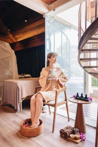 a woman sitting in a chair in a room at Irene Pool Villa Resort, Koh Lipe in Ko Lipe