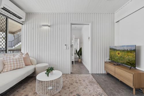 a living room with a couch and a tv at Alex Beachside Pet Friendly 2 Bed Apartment in Alexandra Headland