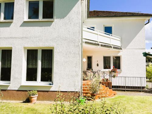 a house with white walls and windows at M9 Ferienwohnung mit Balkon am Waldrand im Ostseeland in Neubukow