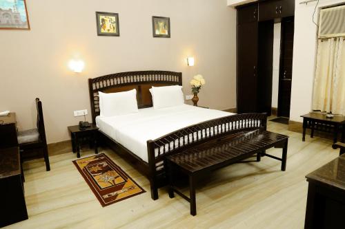a bedroom with a bed and a bench in it at Pearl of Taj Home Stay in Agra