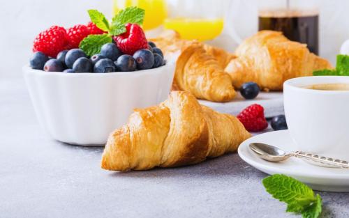 een tafel met croissants en bessen en een fruitschaal bij Martha's Bed and Breakfast in Lincoln