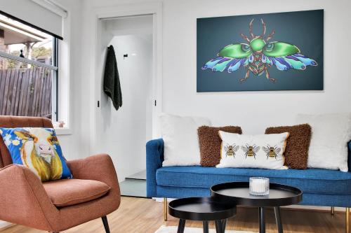 a living room with a blue couch and a table at Bee at Scenic I 2 BR Apartment near Geelong CBD in Geelong