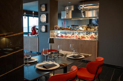 a restaurant with a table with red chairs and a counter at MòN Luxury Rooms SPA in Nicolosi
