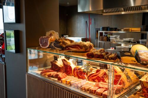 a display case in a bakery with meats and other foods at MòN Luxury Rooms SPA in Nicolosi